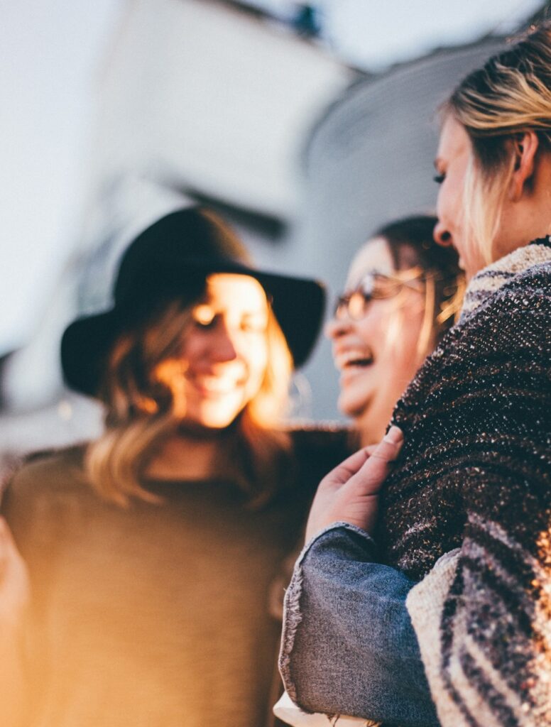 people laughing and talking outside during daytime by Priscilla Du Preez